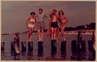 [Two couples standing on pier support stumps]