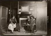 [Family by fireplace with print depicting Robert Gould Shaw Memorial on wall]