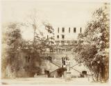 [Destroyed house with statue in garden]