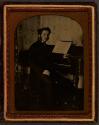 [Man sitting by piano]