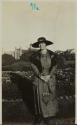[Woman standing in front of shrubbery]