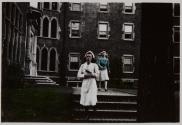 [Nurse descending stairs with woman behind her]