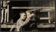 [Two children aiming rifle]