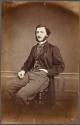 [Man sitting on stool]