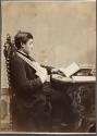 [Man with arm in sling reading book]