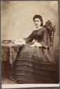 [Woman sitting in front of book]