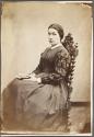 [Seated woman holding book]