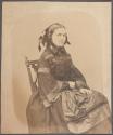 [Woman seated in chair]
