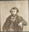 [Man with arm resting on chair back]