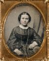 [Woman with dark dress and long chain]