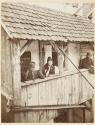 [Man and two women on porch]
