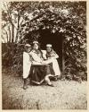 [Woman with two children reading outdoors]