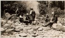 Men around fire at rocky beach, Labrador Trip
