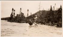 Two men on rock in river, One fishing, Labrador Trip