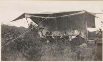 Camping companions at table in tent, Labrador Trip