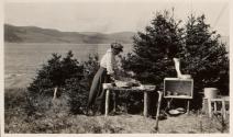 Camping companion washing dishes at campsite, Labrador Trip