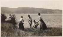 Camping companions cleaning dishes by shore, Labrador Trip