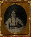[Seated woman wearing a floral dress]