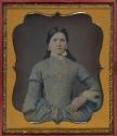 [Young woman wearing a blue dress]