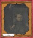 [Child seated on cane chair]