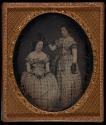 [Two women wearing plaid dresses]