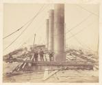 [Men standing next to smokestacks during the construction of the Great Eastern]