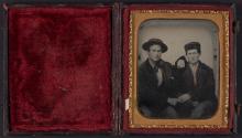 [Two men, seated and holding hands]