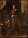 [Woman standing with hand on book]
