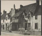 [Woman standing in doorway of building]