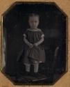 [Little girl, standing on a chair]
