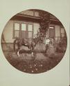 [Saddled horse in yard, woman and boy]