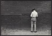 [Man by brick wall]