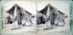 [Black family by log cabin]