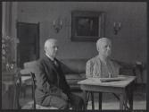 George Eastman posing with bust