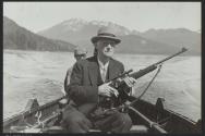 George Eastman with rifle on boat, Alaska Trip