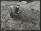George Eastman posing with dead bear, Alaska Trip