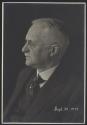 Black and white profile portrait photo of George Eastman with glasses and mustache