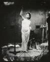 [Female model in Grecian garb posing on dais for photosculpture]
