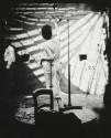[Female model in Grecian garb posing on dais for photosculpture]