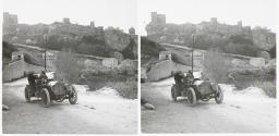 [Car stopped in front of hilltop fortifications]