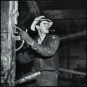 Workman at drilling controls, Cut Bank, Montana