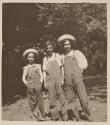 [Three children in overalls]