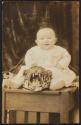 [Baby sitting on leopard rug]