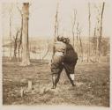 [Two women leaning on stump]