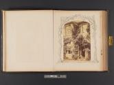 [Man seated at entrance to building, framed by drawing of trees and grass]