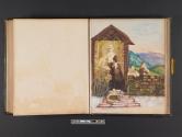 [Women, man and children in scene with small shelter, stone wall, and mountains beyond]