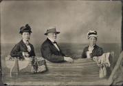 [Samuel Castner Sr. and two women in studio prop boat]