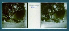[Woman and guide by stone building and stream]