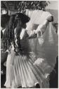 [Young girl holding up dress]