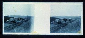 [People and cars on dirt road]